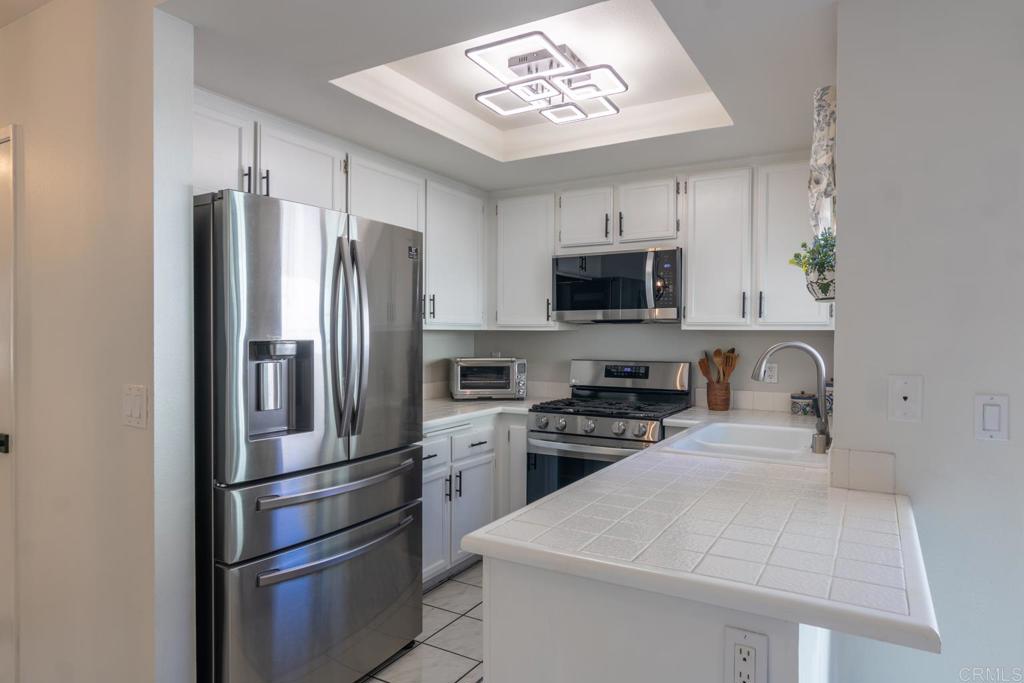 4872 Tarragon Drive Oceanside, CA 92057 - Photo 9 of 25 a kitchen with stainless steel appliances a refrigerator stove and microwave