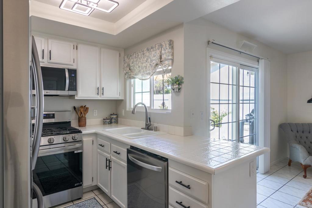 4872 Tarragon Drive Oceanside, CA 92057 - Photo 10 of 25 a kitchen with stainless steel appliances a stove sink microwave and cabinets
