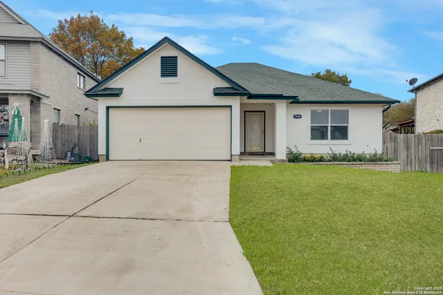 a front view of house with yard and trees in the background