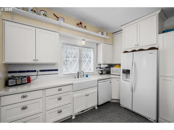 a kitchen with white cabinets and white appliances