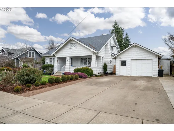 a view of a house with a yard and large tree