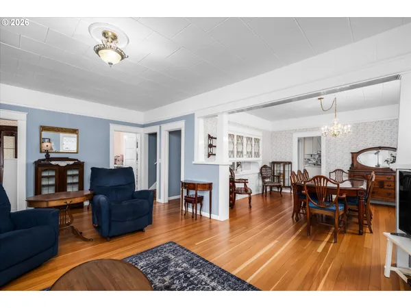 a living room with furniture dining table and a wooden floor