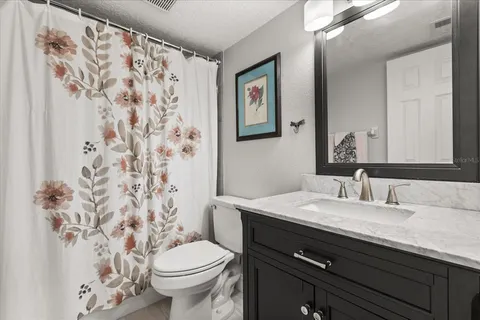 a bathroom with a granite countertop sink a toilet and a mirror
