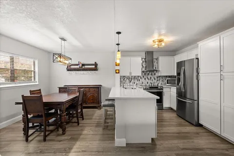 a kitchen with refrigerator and chairs