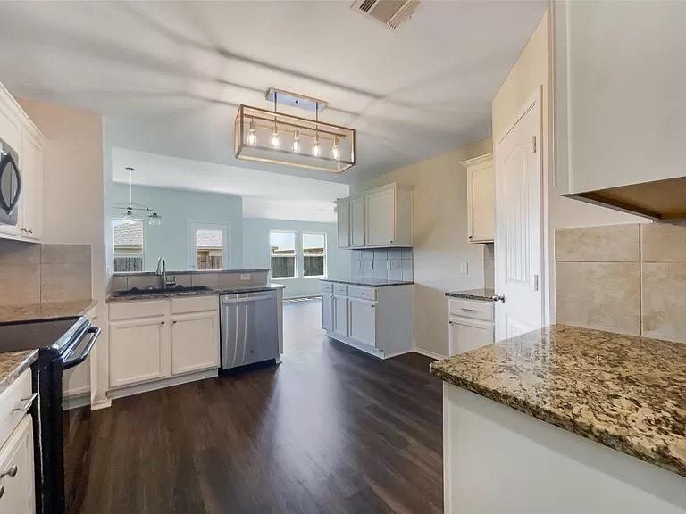1809 Meadow Crest Drive Princeton, TX 75407 - Photo 14 of 20 a kitchen with stainless steel appliances granite countertop a sink cabinets and wooden floor