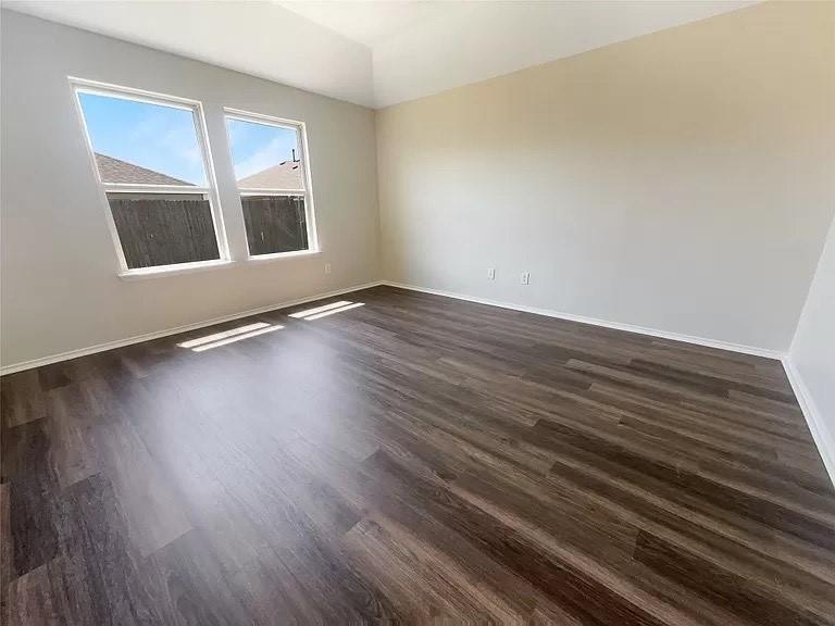 1809 Meadow Crest Drive Princeton, TX 75407 - Photo 16 of 20 a view of an empty room with wooden floor and a window
