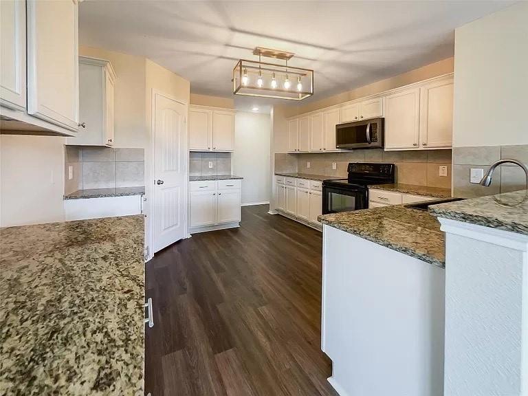 1809 Meadow Crest Drive Princeton, TX 75407 - Photo 4 of 20 a kitchen with stainless steel appliances granite countertop a sink a stove top oven a counter space and cabinets