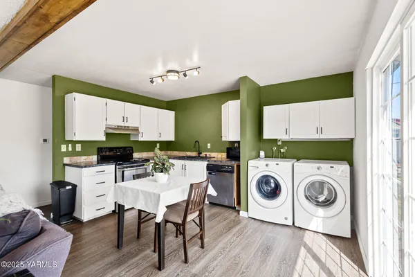 a view of kitchen with sink a microwave and wooden floor
