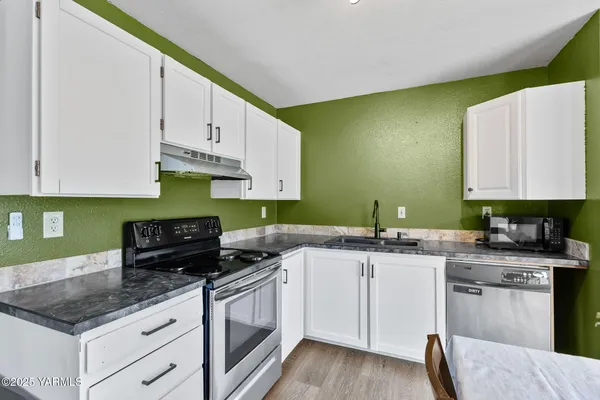 a kitchen with stainless steel appliances granite countertop a sink stove and cabinets