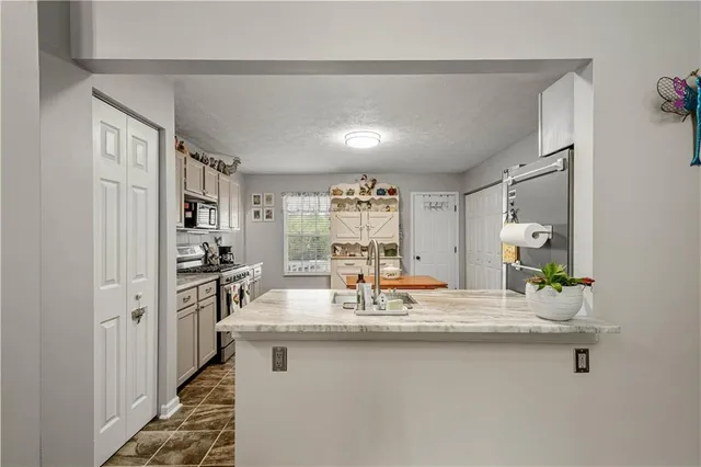 a kitchen with kitchen island a sink stove and refrigerator