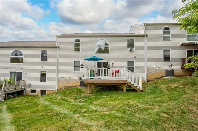 a view of a house with a backyard and chairs