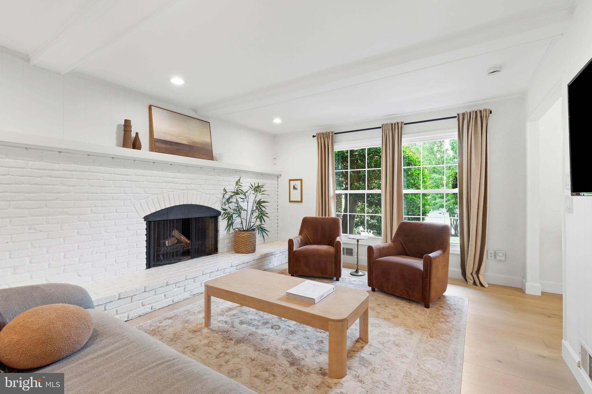 10900 Gainsborough Road Potomac, MD 20854 - Photo 16 of 44 a living room with furniture a fireplace and a large window