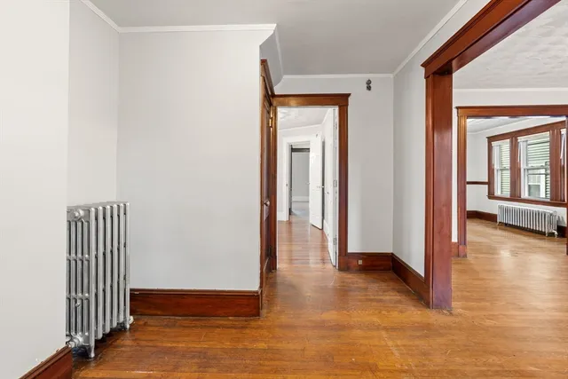 a view of a hallway with wooden floor and stairs