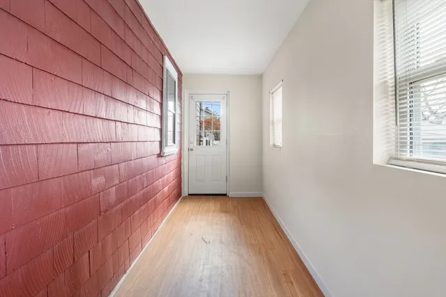 a view of a room with wooden floor and a window