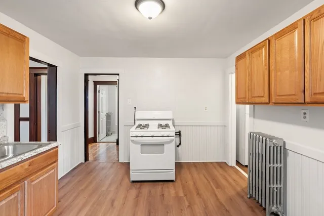 a kitchen with wooden floors and white appliances
