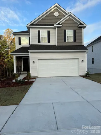 a front view of a house with yard and parking