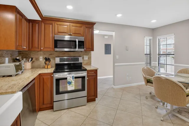a kitchen with granite countertop a sink cabinets and stainless steel appliances