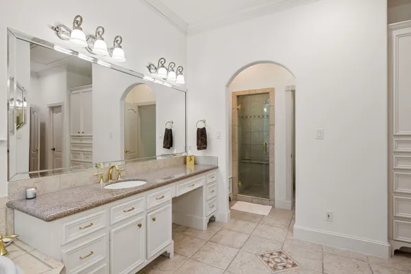 a spacious bathroom with a granite countertop sink a mirror and a shower