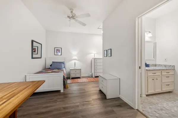 a kitchen with stainless steel appliances granite countertop white cabinets a sink a stove a microwave and wooden floors