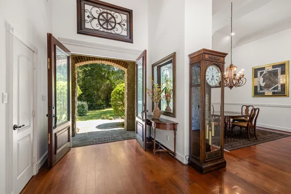 a view of a hallway with wooden floor and furniture