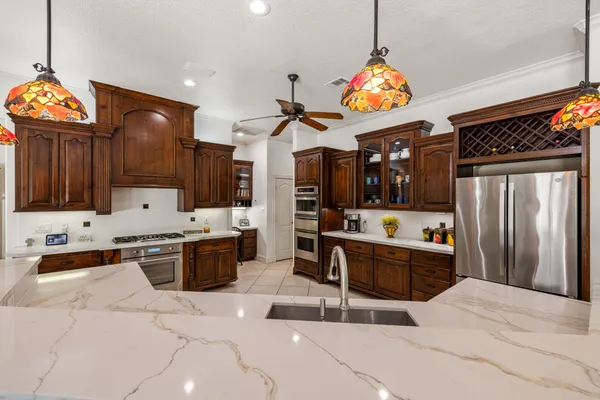 a large kitchen with stainless steel appliances kitchen island granite countertop a stove refrigerator and a sink