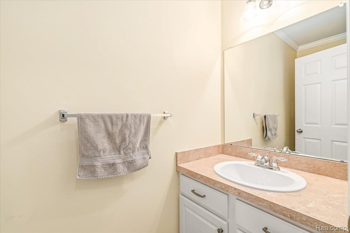 49105 Hawksburry Road Canton, MI 48188 - Photo 15 of 51 Bathroom vanity featuring a drop-in sink with a chrome faucet, solid surface countertop, and white cabinetry with brushed nickel hardware