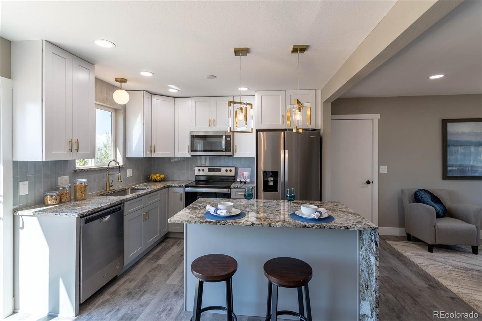 4465 South Eagle Circle Aurora, CO 80015 - Photo 5 of 26 a kitchen with refrigerator a sink and chairs