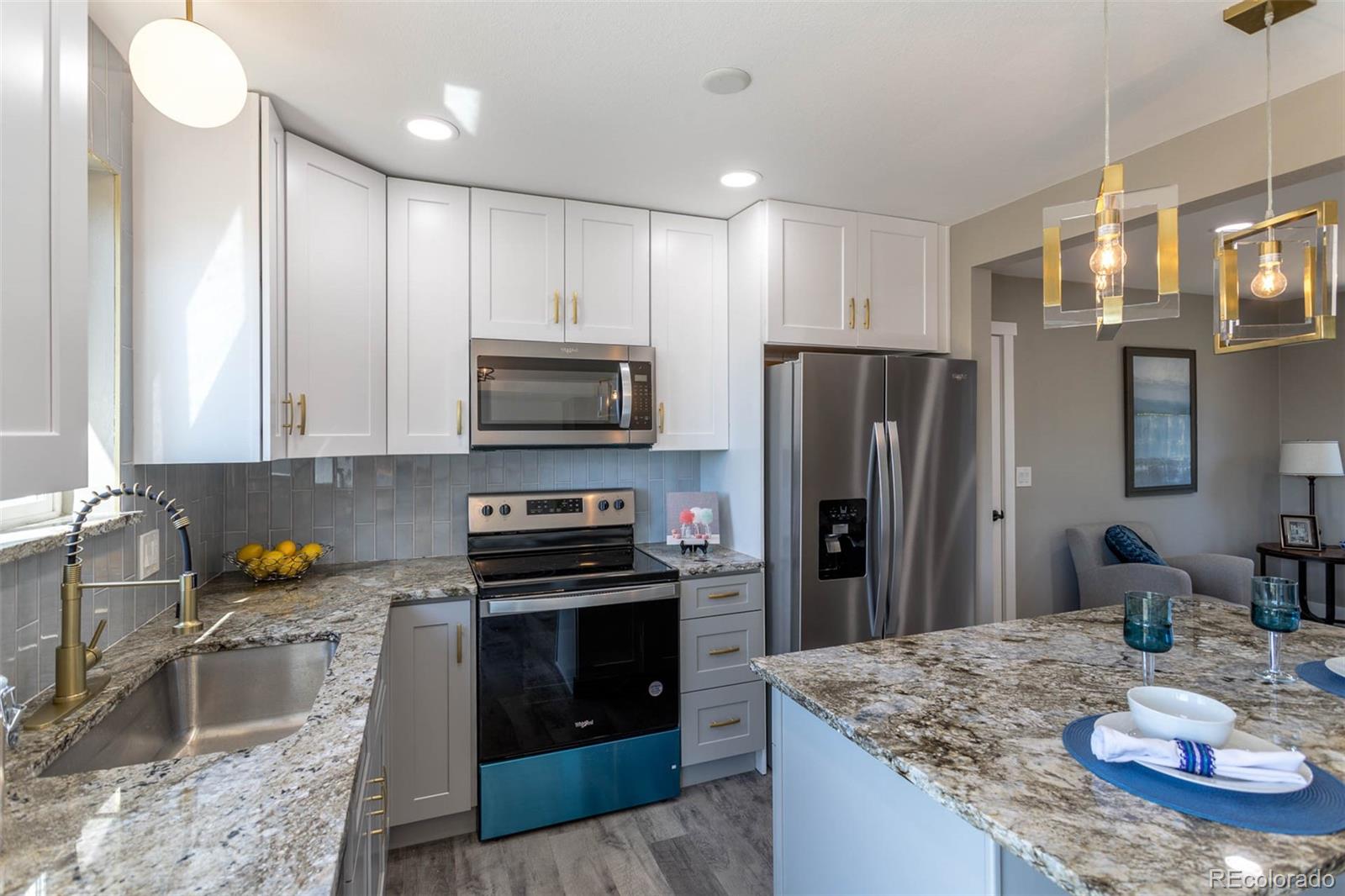 4465 South Eagle Circle Aurora, CO 80015 - Photo 6 of 26 a kitchen with stainless steel appliances granite countertop a sink stove and refrigerator