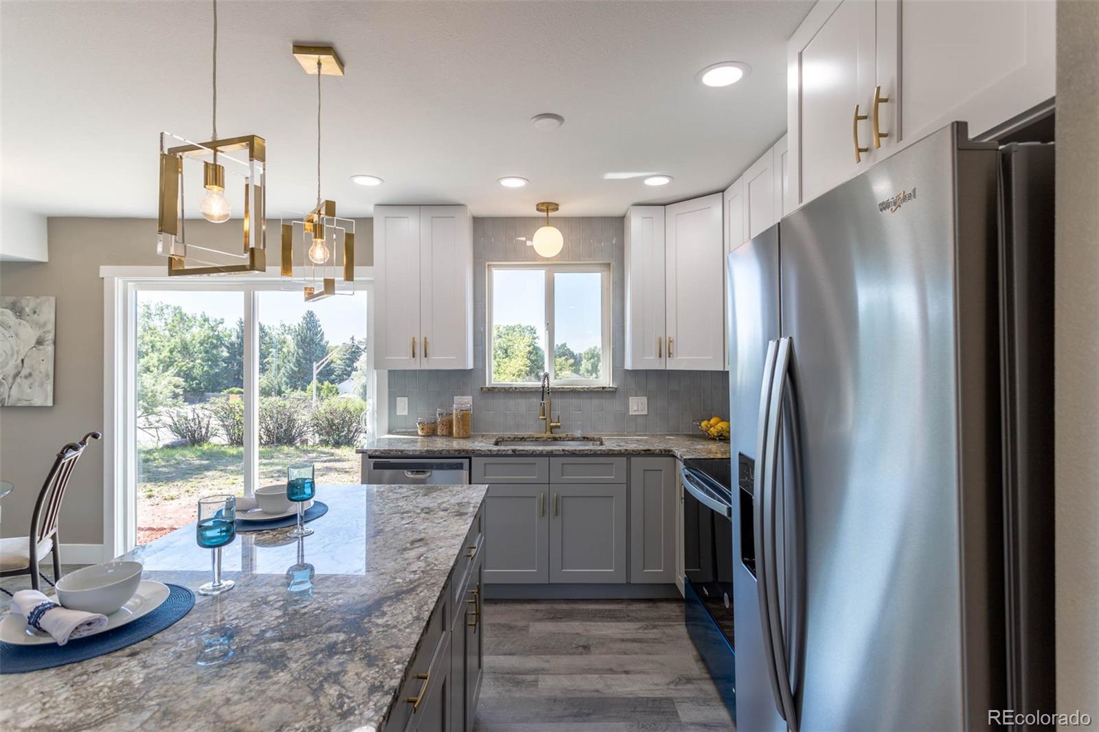 4465 South Eagle Circle Aurora, CO 80015 - Photo 7 of 26 a kitchen with stainless steel appliances granite countertop a refrigerator a sink a stove and a wooden floors