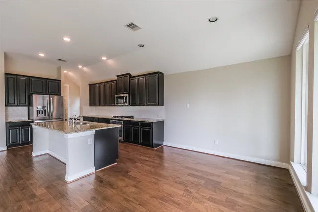 a kitchen with stainless steel appliances granite countertop a stove top oven and sink