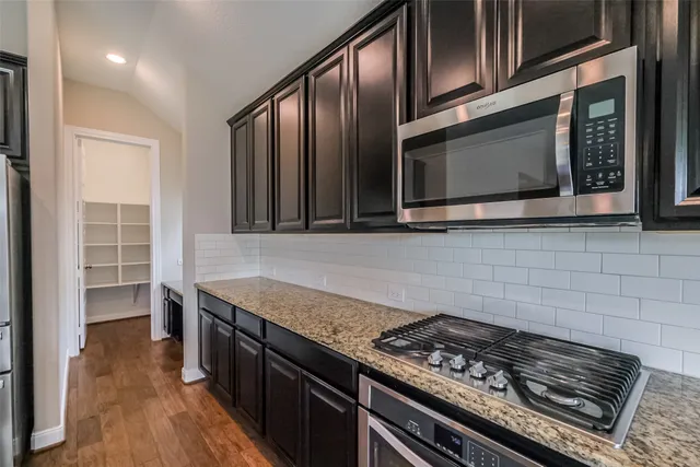 a kitchen with granite countertop stainless steel appliances and wooden cabinets