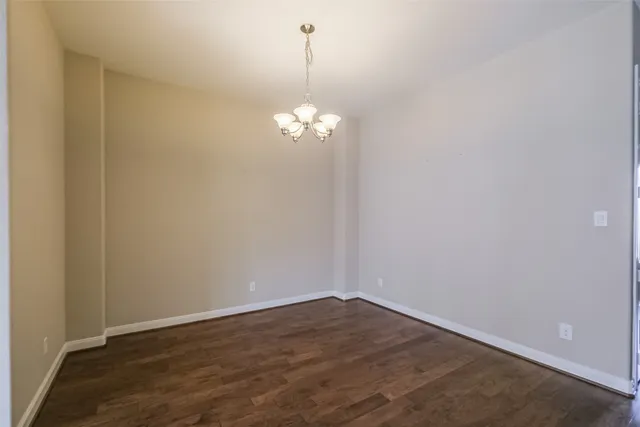a view of a room with wooden floor and chandelier