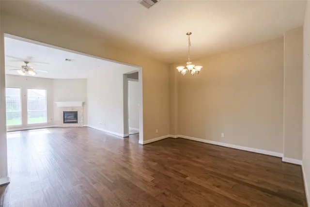 a view of a room with wooden floor and chandelier