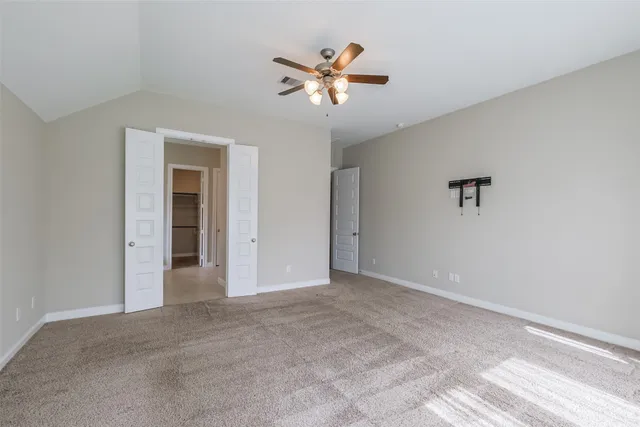 a view of an empty room with a ceiling fan