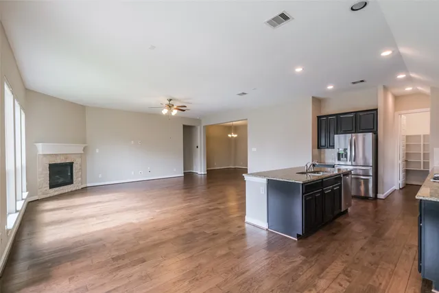 an open kitchen with a sink and a stove top oven
