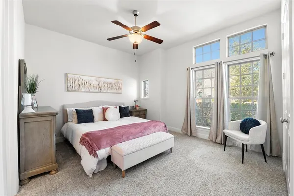 a bedroom with a bed and a large window