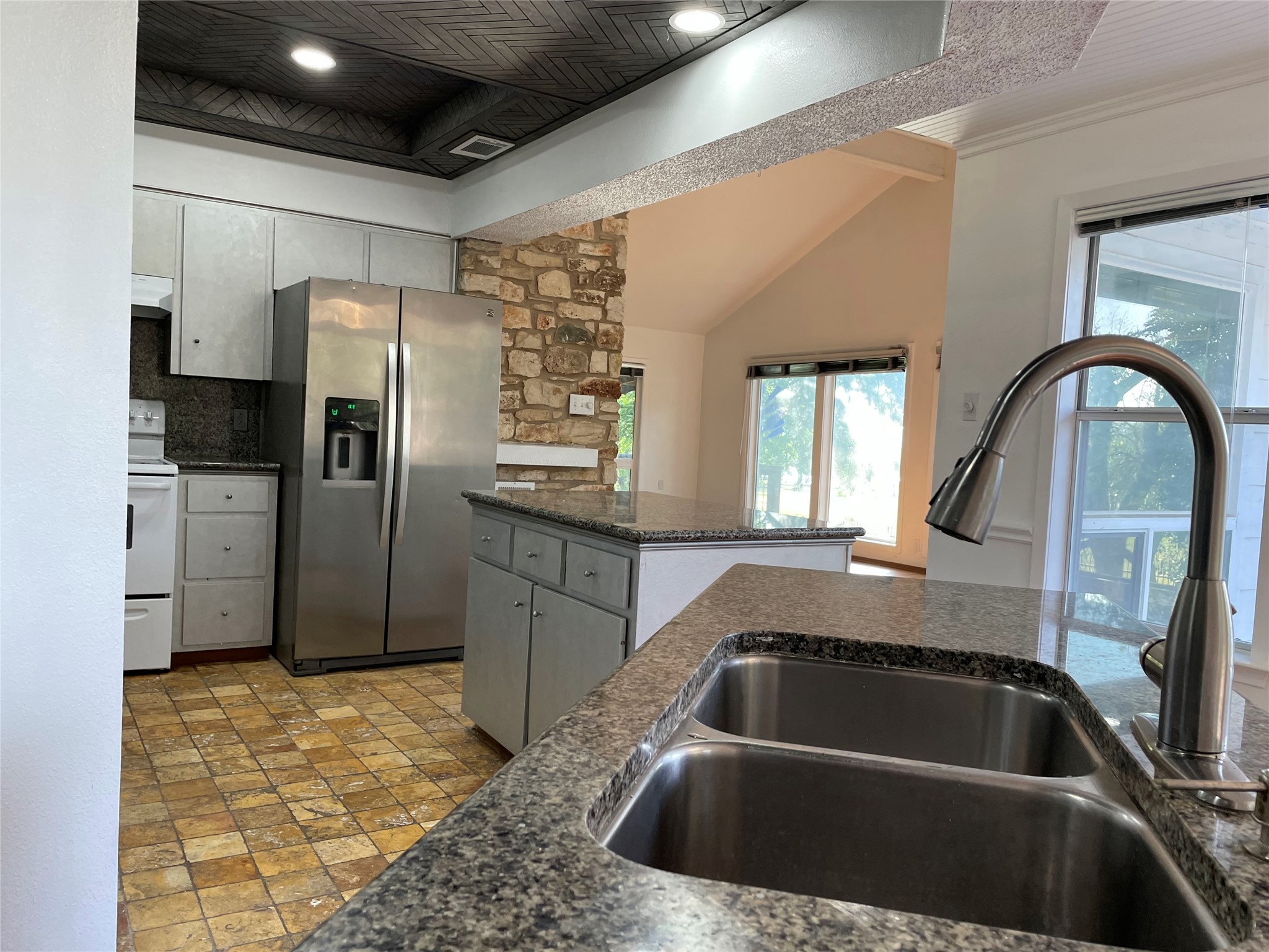 5802 Longhorn Landing Austin, TX 78734 - Photo 17 of 38 Kitchen featuring stainless steel refrigerator with ice dispenser, electric range, gray cabinetry, dark stone countertops, and backsplash