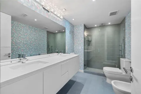 a bathroom with a double vanity sink toilet and shower