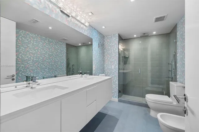 a bathroom with a double vanity sink toilet and shower