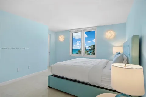a bedroom with a bed and a large mirror on dresser