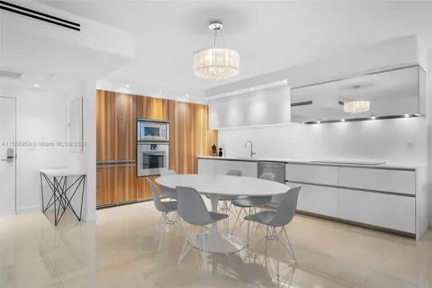 a kitchen with a dining table chairs appliances and cabinets