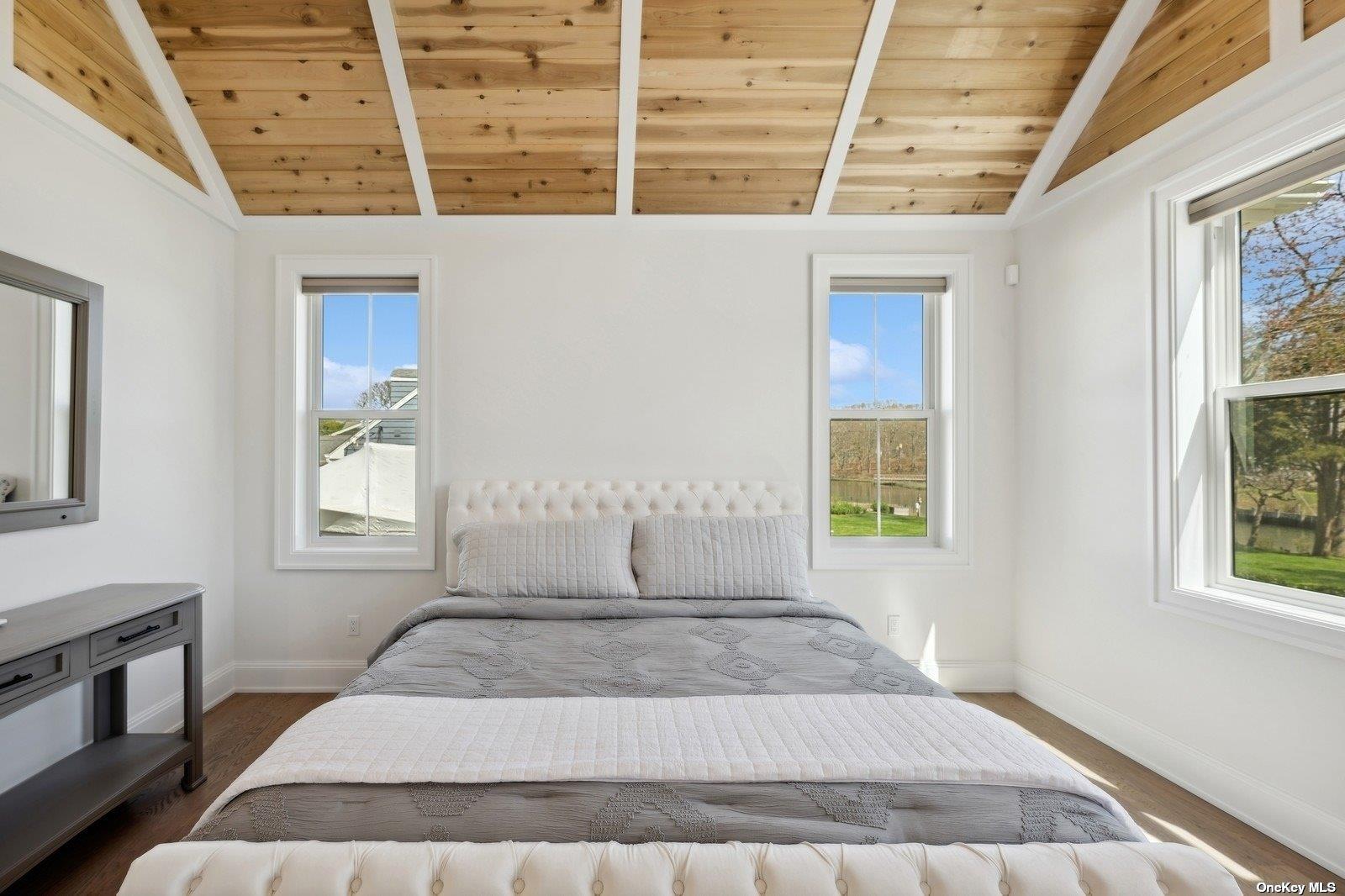 910 Glenn Road Southold, NY 11971 - Photo 14 of 33 a view of a bedroom with wooden floor and windows