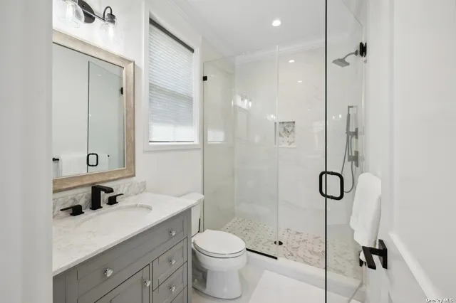 a bathroom with a granite countertop sink toilet and shower