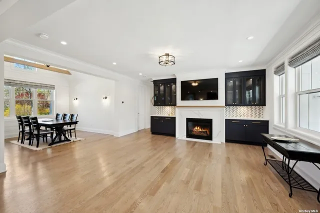 a living room with furniture a fireplace a flat screen tv and kitchen view