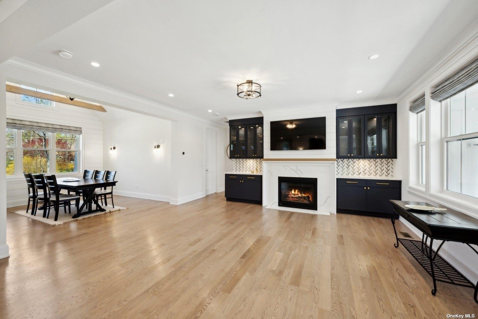 910 Glenn Road Southold, NY 11971 - Photo 3 of 33 a living room with furniture a fireplace a flat screen tv and kitchen view