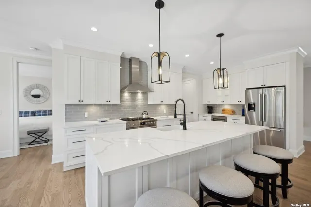 a kitchen with a sink dishwasher a stove a dining table and chairs with wooden floor