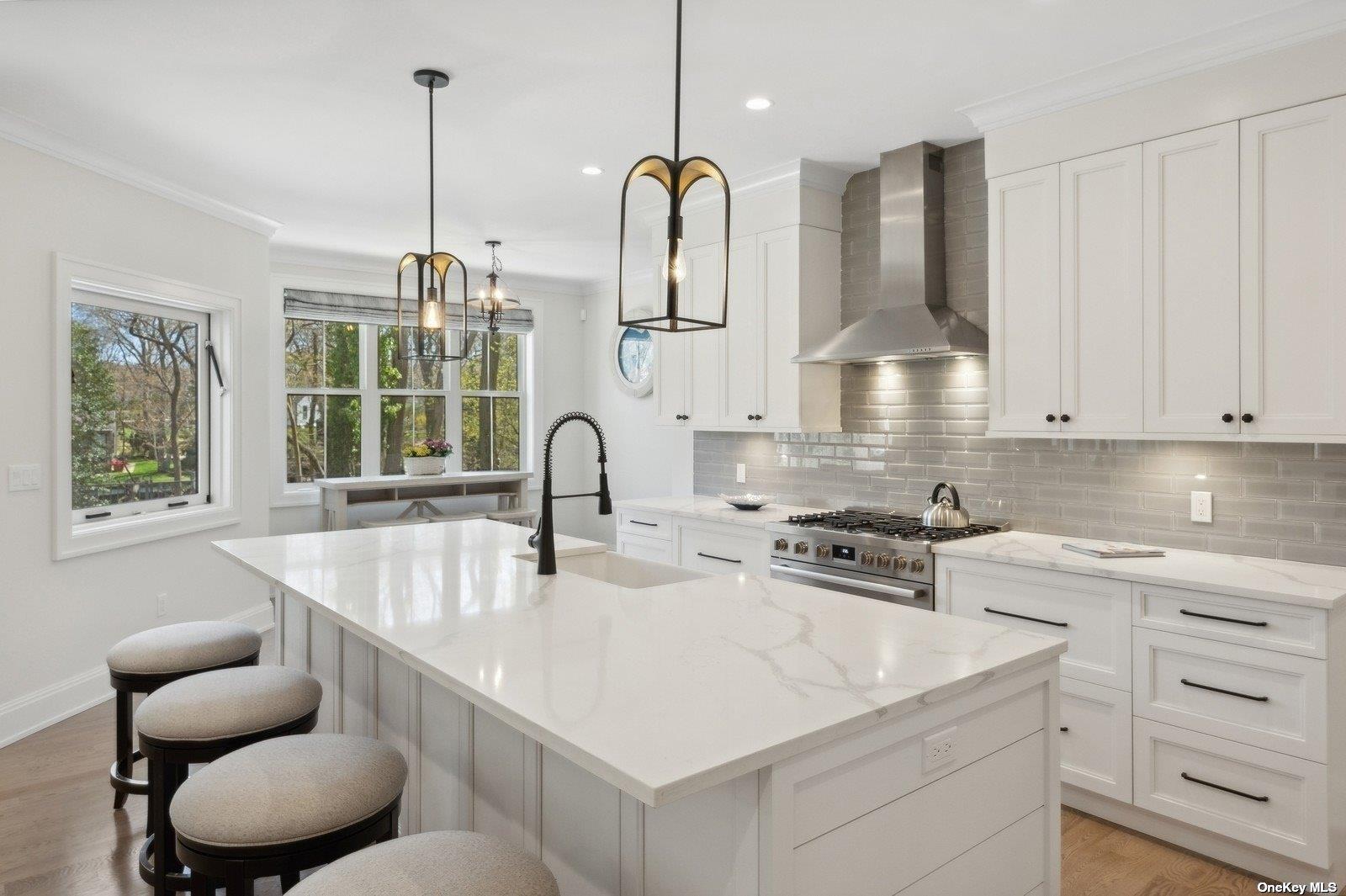 910 Glenn Road Southold, NY 11971 - Photo 9 of 33 a kitchen with stainless steel appliances granite countertop a sink a stove and a wooden floor