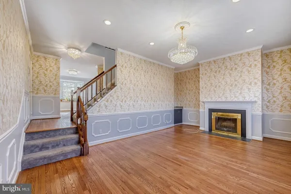 a view of a livingroom with wooden floor and a fireplace