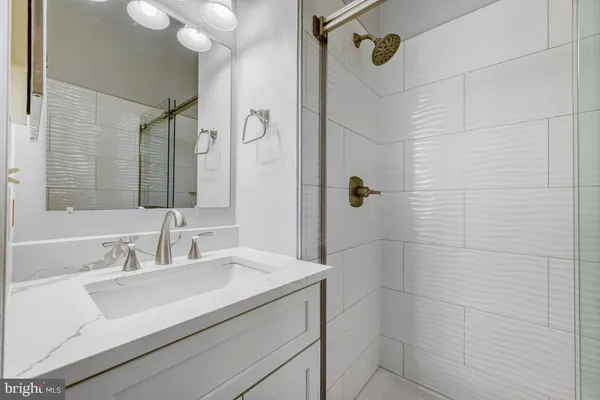 a bathroom with a sink shower and a mirror