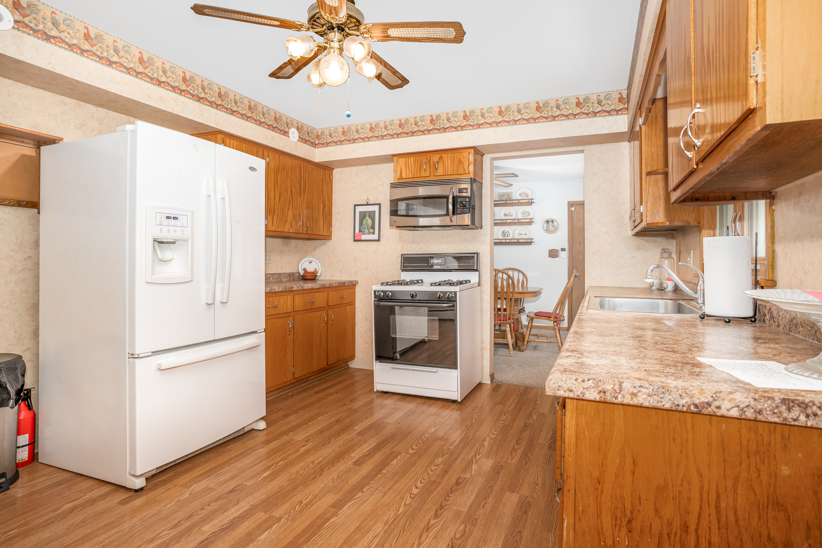 11025 Bryant Road Mokena, IL 60448 - Photo 7 of 21 a kitchen with stainless steel appliances granite countertop a refrigerator a stove and a wooden floors